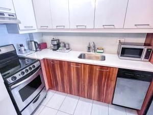 a small kitchen with a sink and a microwave at Downtown Central Residences in Montréal