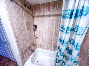 a bathroom with a tub and a shower with a shower curtain at Downtown Central Residences in Montréal +10 photos