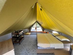 a yellow tent with a bed in a room at Le Tipi 2 in Lecci