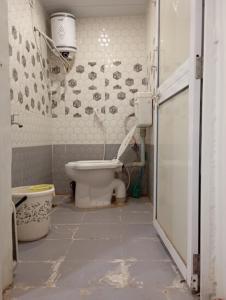 a bathroom with a white toilet in a room at Ashish Aram Ghar in Ujjain