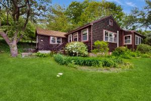 ein Haus mit einem grünen Rasen davor in der Unterkunft Rustic Rockport Cottage in Rockport
