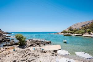 a beach with a group of boats in the water at Finikas Resort Sfakia - Seaside Rooms in Loutro +70 photos
