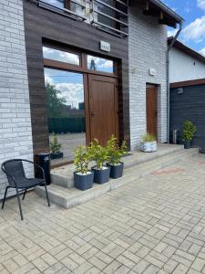 una panchina seduta di fronte a un edificio con piante in vaso di Hostel Kandulski a Poznań Altre 34 foto