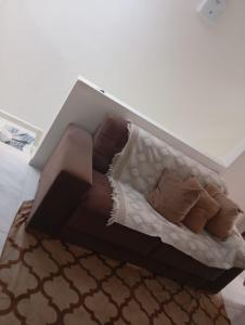 a couch with pillows on a bed in a room at Casa para temporada no São João in Campina Grande