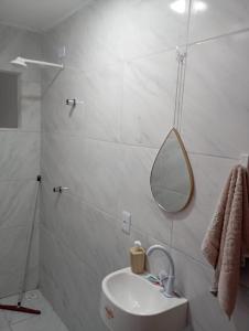 a white bathroom with a sink and a mirror at Casa para temporada no São João in Campina Grande