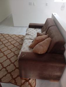 a brown couch with two pillows on it at Casa para temporada no São João in Campina Grande