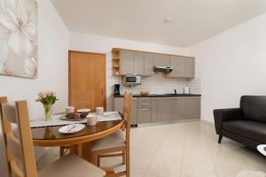 a living room and kitchen with a table and a couch at Apartments Kvarner 2 in Malinska