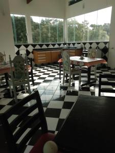 a dining room with tables and chairs on a checkered floor at Casa do Pescador in Peruíbe