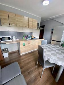 a kitchen with a table and a refrigerator at Hostel Kandulski in Poznań
