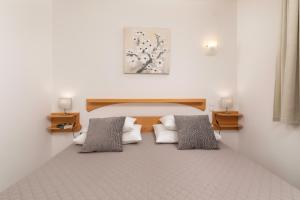 a room with a bed with two pillows at Apartments Kvarner 2 in Malinska