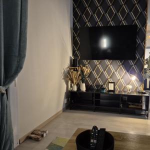 a living room with a tv on a wall at Lapsou in La Chapelle-Montbrandeix