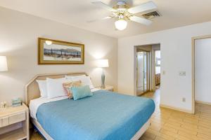 una camera con letto blu e ventilatore a soffitto di Southwest Getaway with Fenced Yard in Chandler! a Chandler