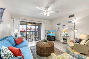 a living room with a blue couch and a ceiling fan at Dans Florida Condos Sea Life at Runaway Bay in Bradenton Beach
