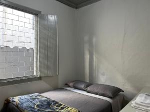 a small room with a bed and a window at Casa 89 in Diamantina