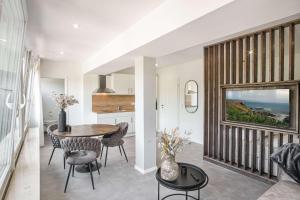 a dining room and kitchen with a table and chairs at Meer in Sicht in Eckernförde +5 photos