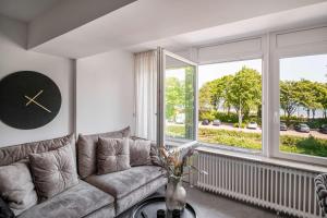a living room with a couch and a large window at Meer in Sicht in Eckernförde