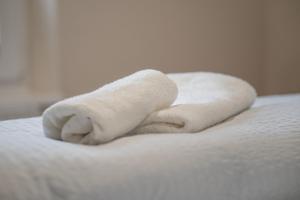 a stack of towels sitting on top of a bed at Hotel Seepferdchen Zimmer 7 Eckernförde Self-Check-In in Eckernförde +5 photos