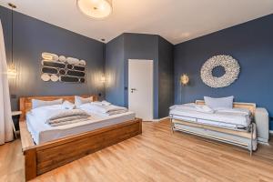 two beds in a room with blue walls at Hotel Seepferdchen Zimmer 7 Eckernförde Self-Check-In in Eckernförde