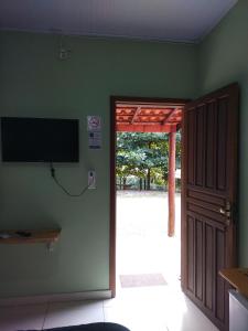 an open door to a room with a flat screen tv at pousada da Serra PETAR in Iporanga