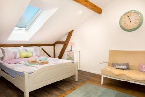 a bedroom with a bed and a clock on the wall at Ferienwohnung Kunterbunt Eckernförde in Eckernförde
