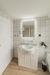 a white bathroom with a sink and a mirror at Hotel Seepferdchen Zimmer 6 Eckernförde Self-Check-In in Eckernförde