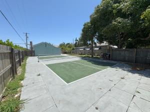 un campo da tennis in un vialetto con una racchetta da tennis di The Pickleball Beach Bungalow a Lake Worth