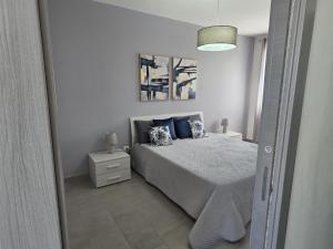 a bedroom with a bed with blue pillows at A Casa di Angela in Capaci