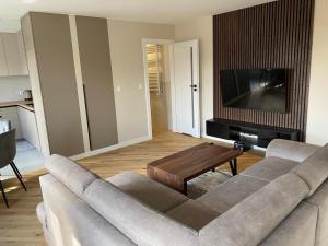 a living room with a couch and a flat screen tv at Apartament Parkowy in Augustów