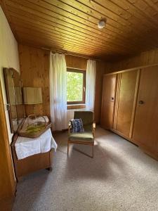 ein Schlafzimmer mit einem Bett und einem Stuhl und einem Fenster in der Unterkunft Erholungsoase im Vorharz in Katlenburg-Lindau