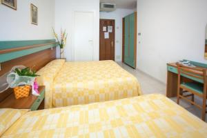 ソットマリーナにあるホテル グラン プリのベッド2台とデスクが備わるホテルルームです。