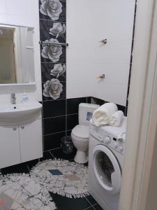 a bathroom with a toilet and a washing machine at Уютная квартира ЖК Orynbor towers in Astana