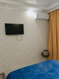 a bedroom with a flat screen tv on the wall at Уютная квартира ЖК Orynbor towers in Astana