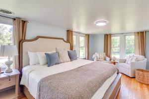 a bedroom with a bed and a chair and windows at Steps to Susquehanna River Hot Tub Hideaway! in Dauphin