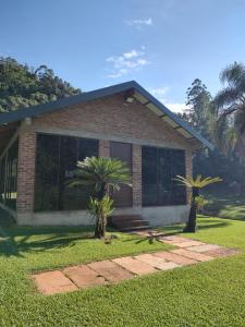 a house with two palm trees in front of it at Refúgio da Família Koch - casa de campo in Sinimbu
