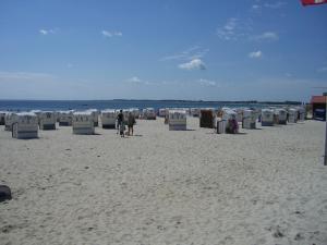 a beach with chairs and people walking on the sand at Apartment Seestern in Großenbrode