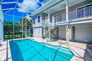 a swimming pool in front of a house at Halliday in Sanibel