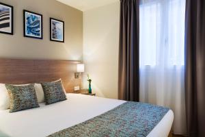 a hotel room with a bed and a window at Citadines Wilson Toulouse in Toulouse +18 photos