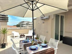 a patio with a table and an umbrella at Casa Vivì in Porto SantʼElpidio +24 photos