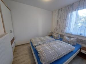 a small bedroom with a bed and a window at Ferienquartier T5 Bahnhofstraße 6 in Trassenheide