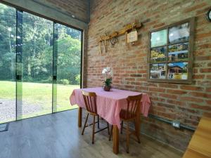 a dining room with a pink table and chairs at Refúgio da Família Koch - casa de campo in Sinimbu