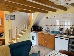 a kitchen with a washer and dryer and a staircase at Gîte Chez Charlot in Chanaz