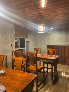 a dining room with a table and wooden chairs at Lombok Grace Bungalows in Tetebatu