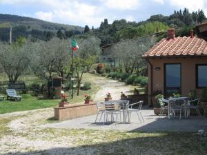 a patio with a table and chairs in a garden at Agriturismo Il Colle in Bagno a Ripoli