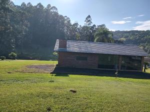 a brick building in a field with trees in the background at Refúgio da Família Koch - casa de campo in Sinimbu +7 photos