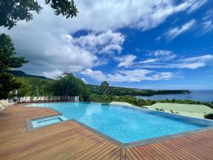 una piscina con vista al agua en Le Rayon Vert - Hôtel & Restaurant VUE SUR MER, en Deshaies