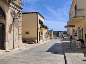 an empty street in a town with buildings at A due passi dal portale in Ragusa