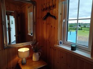 a lamp on a table in a room with a window at Shepard's Delight in Lisnaskea