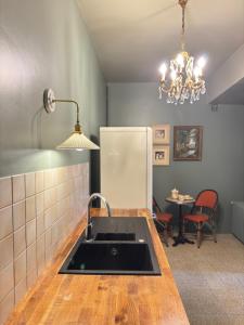 a kitchen with a sink and a table and a chandelier at Maison de Beaugency centre boîte à clefs vélos dans la maison in Beaugency +5 photos