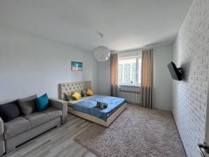 a living room with a couch and a table in it at ЖК Времена года Весна Кабанбай Батыра 46 in Taldykolʼ