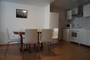 a kitchen and dining room with a table and chairs at Apartamentos Turísticos Río Gallego (Apartamento Huesca) in Huesca